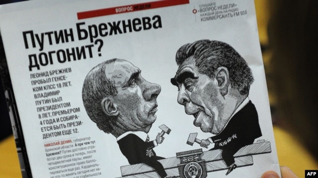 A man looks at a cartoon depicting Premier Vladimir Putin (left) and former Soviet leader Leonid Brezhnev in a magazine in Moscow.