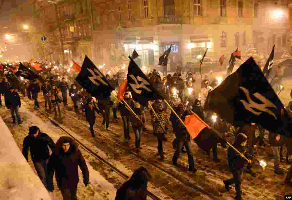 Nationalists, carrying torches, march in the western Ukrainian city of Lviv to mark the 95th anniversary of a battle near the small city of Kruty. Some 300 students, cadets, and schoolboys were killed in a battle against the Red Army on January 29, 1918, to protect the newborn Ukrainian People's Republic against Bolshevik aggression. (AFP/Yuriy Dyachyshyn)