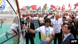 Turkmen President Gurbanguly Berdymukhammedov (right) meets participants of a leg of the windsurfing World Cup at the Turkmen Caspian Sea resort of Awaza on July 1.
