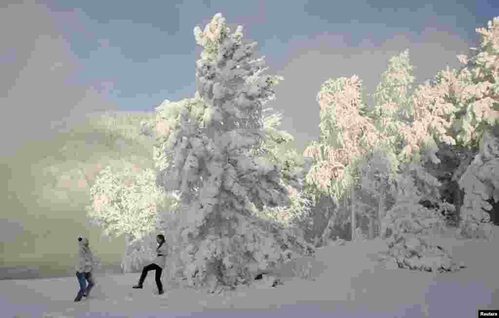 Two women play in the snow in temperatures of minus 30 degrees Celsius in the Siberian city of Krasnoyarsk.