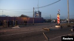 Police stand near debris at the site of a suicide bombing at a checkpoint on the border between the regions of North Ossetia and Ingushetia in October 2012.