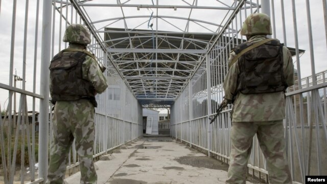 Uzbek border guards keep watch on a bridge across the Kara-Su River border between Kyrgyzstan and Uzbekistan. The Tashkent government is the only former Soviet administration to still require exit visas for its citizens to leave the country.