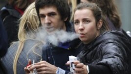 Russian students smoke on a street in Moscow