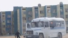 Kazakhstan -- A protester runs from a police vehicle on fire in the Kazakh town of Zhanaozen in this still image taken from video acquired by Reuters TV, 16Dec2011  