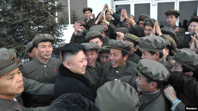Kim Jong Un (center) celebrates with scientists and technicians after the launch of a rocket in mid-December.