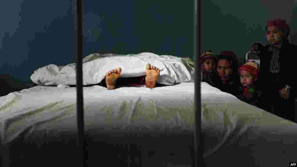 The family of a 5-year-old Afghan girl who was allegedly raped by a 22-year-old man looks on as she lies in a hospital bed in Mazar-e Sharif. The alleged rapist was detained by police. (AFP/Qais Usyan)