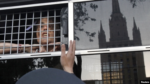 An opposition activist looks out from a police bus after being detained near a protest camp on May 17.
