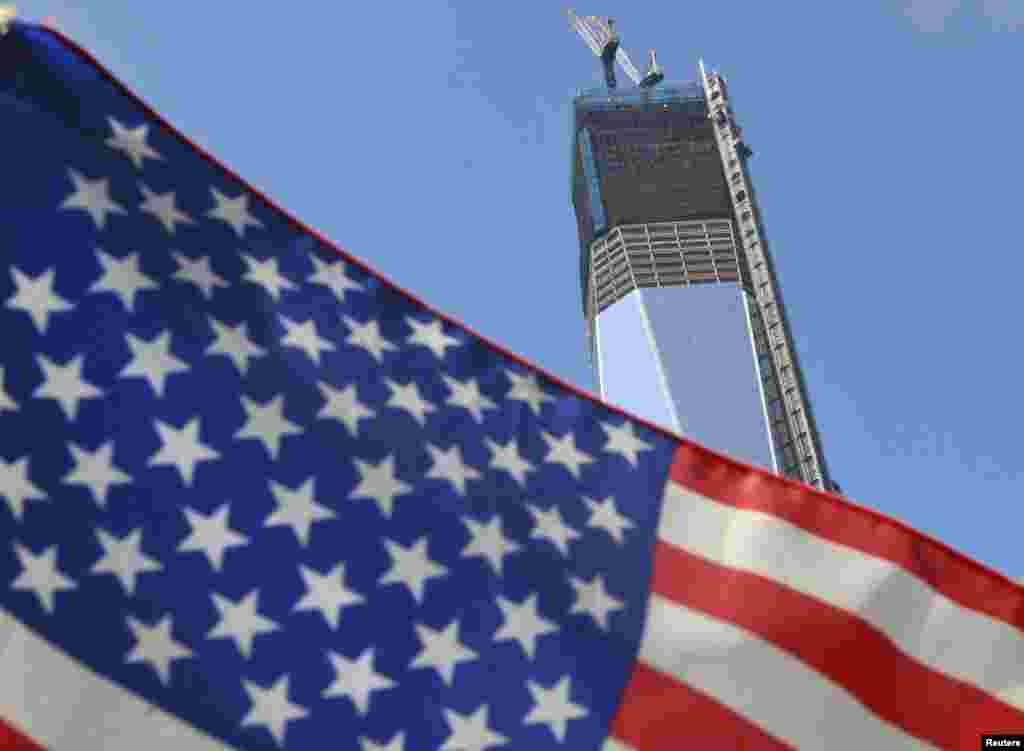 The unfinished One World Trade Center, the flagship of the redeveloped site, is seen behind a U.S. flag on September 7, 2012. The tower, due to be completed in 2014, will rise to 1,776 feet.