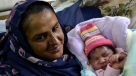 Mukhtar Mai shows off her newborn baby boy at a hospital in Multan in November 2011.