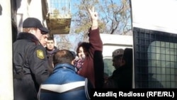 Azerbaijani journalist Khadija Ismayilova gestures to supporters at a court hearing earlier this year.