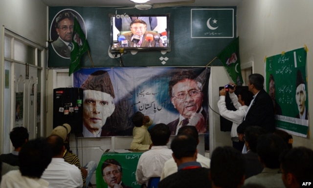 Activists of the All Pakistan Muslim League watch in Karachi as Musharraf speaks to reporters about his return from self-imposed exile on March 1.