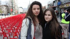 Lamia Alibegovic, 13, and Elma Ocuz, 14, visit the "Sarajevo Red Line" installment.