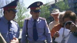 Полиция қызметкерлері жиналғандардың плакаттарын алуға әрекеттеніп жатыр. Семей, 28 сәуір 2012 год.