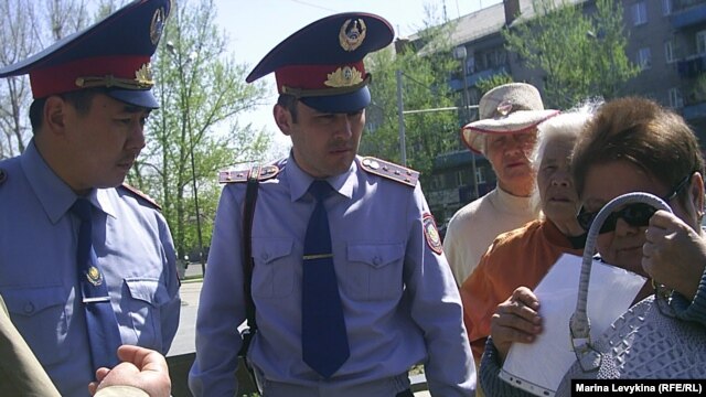 Полиция қызметкерлері жиналғандардың плакаттарын алуға әрекеттеніп жатыр. Семей, 28 сәуір 2012 год.