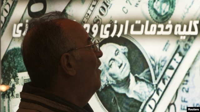 An Iranian man walks past a currency-exchange shop in northern Tehran. Sanctions on Iran have caused the rial to plunge in value, driving up the cost of imports.
