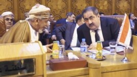 Iraqi Foreign Minister Hoshiyar Zebari (R) talks with an Omani foreign affairs representative at the Arab League foreign ministers' meeting on Syria at the Arab League headquarters in Cairo on November 12.