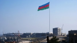 An enormous Azerbaijani flag flies above the construction site of the Crystal Hall on the Caspian shoreline in Baku earlier this year.