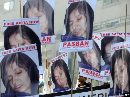 Pakistani protesters carry photographs of Aafia Siddiqui during a march to support her in Karachi on September 23.