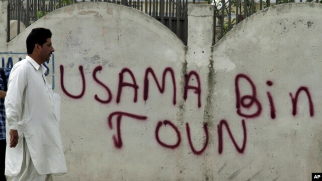 A man walks past graffiti reading "Usama Bin Town" in Abbottabad on May 6.