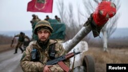 A serviceman stands guard as a Ukrainian Army convoy of heavy equipment prepares to pull back from the Debaltseve region on February 26.