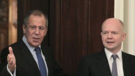 Foreign Minister Sergei Lavrov (L) shows the way to his British counterpart William Hague as they meet in Moscow