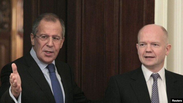 Foreign Minister Sergei Lavrov (L) shows the way to his British counterpart William Hague as they meet in Moscow