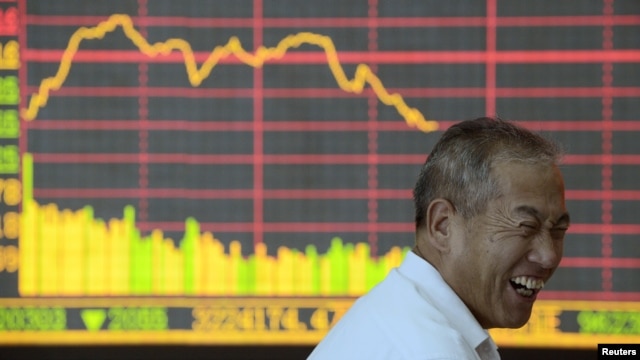 An investor reacts in front of an electronic board showing graph of stock indexes at a brokerage house in Taiyuan, Shanxi province, in July.