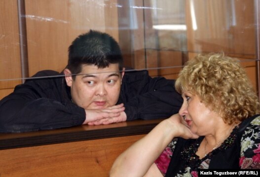 Former Kyrgyz State Committee for National Security agent Aldayar Ismankulov (behind glass) with lawyer Svetlana Murzina in court on June 6