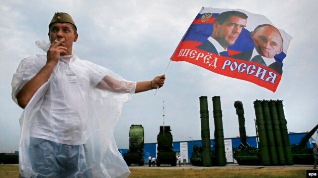 سامانه اس-۳۰۰ (در تصویر پشت سر مردی که عکس رئیس‌جمهوری و نخست وزیر روسیه را در دست دارد)