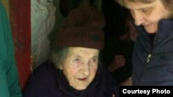 Stana Cerovic is shown as social workers help her to move from her village to a home for the elderly in late May. (Photo courtesy of Radio and Television of Montenegro)