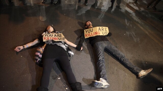 Cypriot protestors lie on the ground with signs during a demonstration against an EU bailout deal outside the parliament in the capital, Nicosia, on March 19.