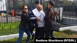 Жительницу города Семей Кенжегайши Рахимбаеву (в центре) задерживают у здания генеральной прокуратуры. Астана, 16 сентября 2015 года.