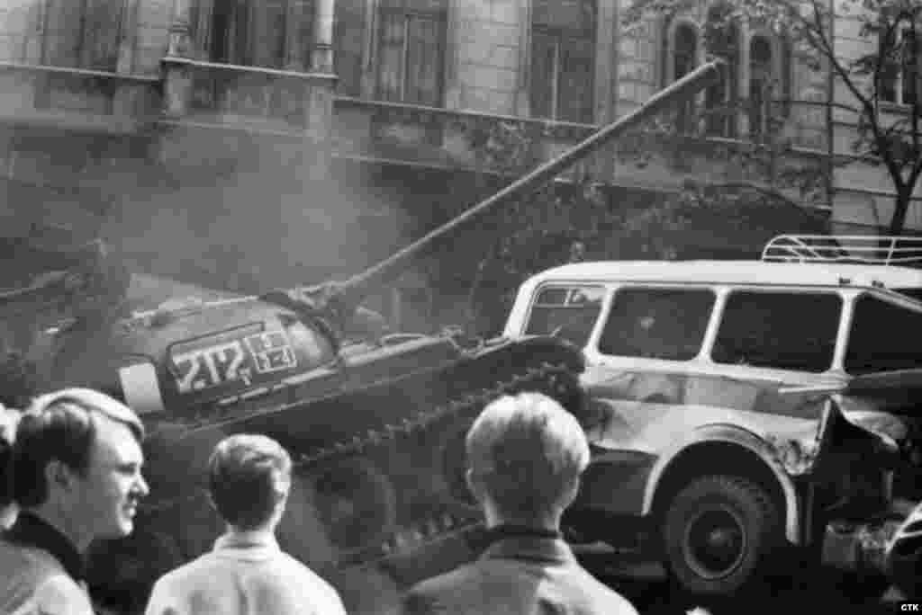 A Soviet tank rams a city bus after protesters set up a barricade to block Soviet forces near the Czechoslovak radio headquarters.