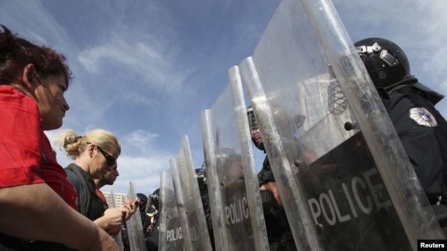 Protesters face a police barricade in front of a government building in Pristina on October 17.