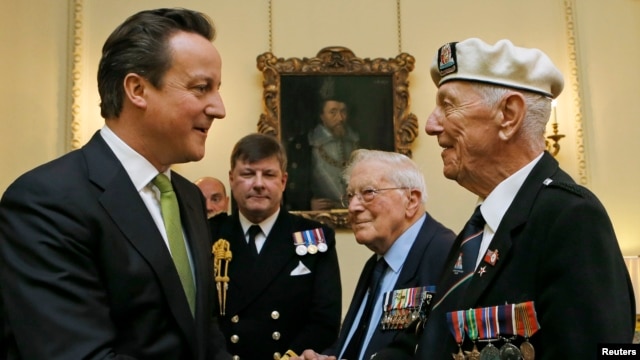 British Prime Minister David Cameron (left) meets Arctic Convoy veterans during a special medal presentation ceremony on Downing Street on March 19. 