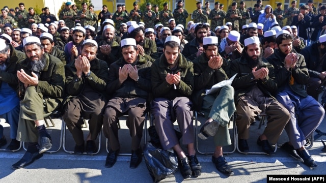 Released Taliban prisoners sit on chairs and pray during a ceremony in Pul-e Charkhi jail on January 4. Observers wonder how many of them will simply rejoin the fight?