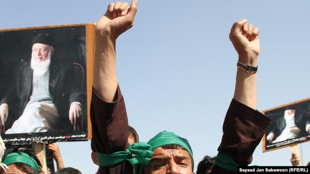 Supporters of slain former Afghan President Burhanuddin Rabbani shout slogans and hold up his portrait during a protest against the Taliban and Pakistan in Kabul on September 27.