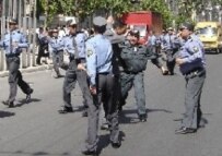 Police wielding batons against a demonstrator in Baku today. Officials later denied they used force against protesters
