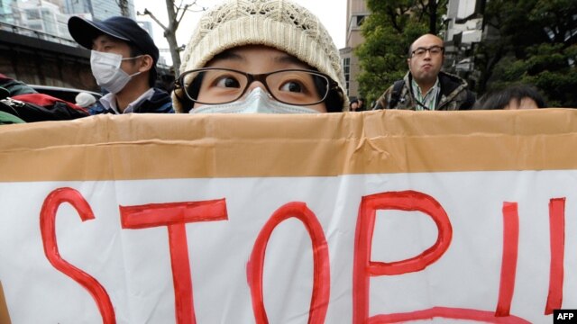 Members of various civic groups hold placards in Tokyo denouncing the use of nuclear power during a rally in front of the headquarters of the Tokyo Electric Power Company.
