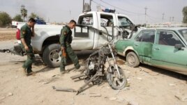 Iraqi security personnel inspect the site of a bomb attack in Kirkuk on October 24, where a child was killed.