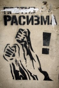 The banner originally read 'Against Racism' but the 'Against' was rubbed out