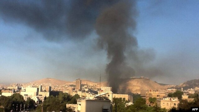 Smoke rises from the site of explosions in central Damascus on September 26.