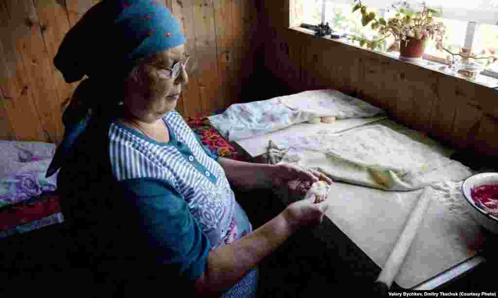 A woman prepares a traditional dish, blueberry dumplings.