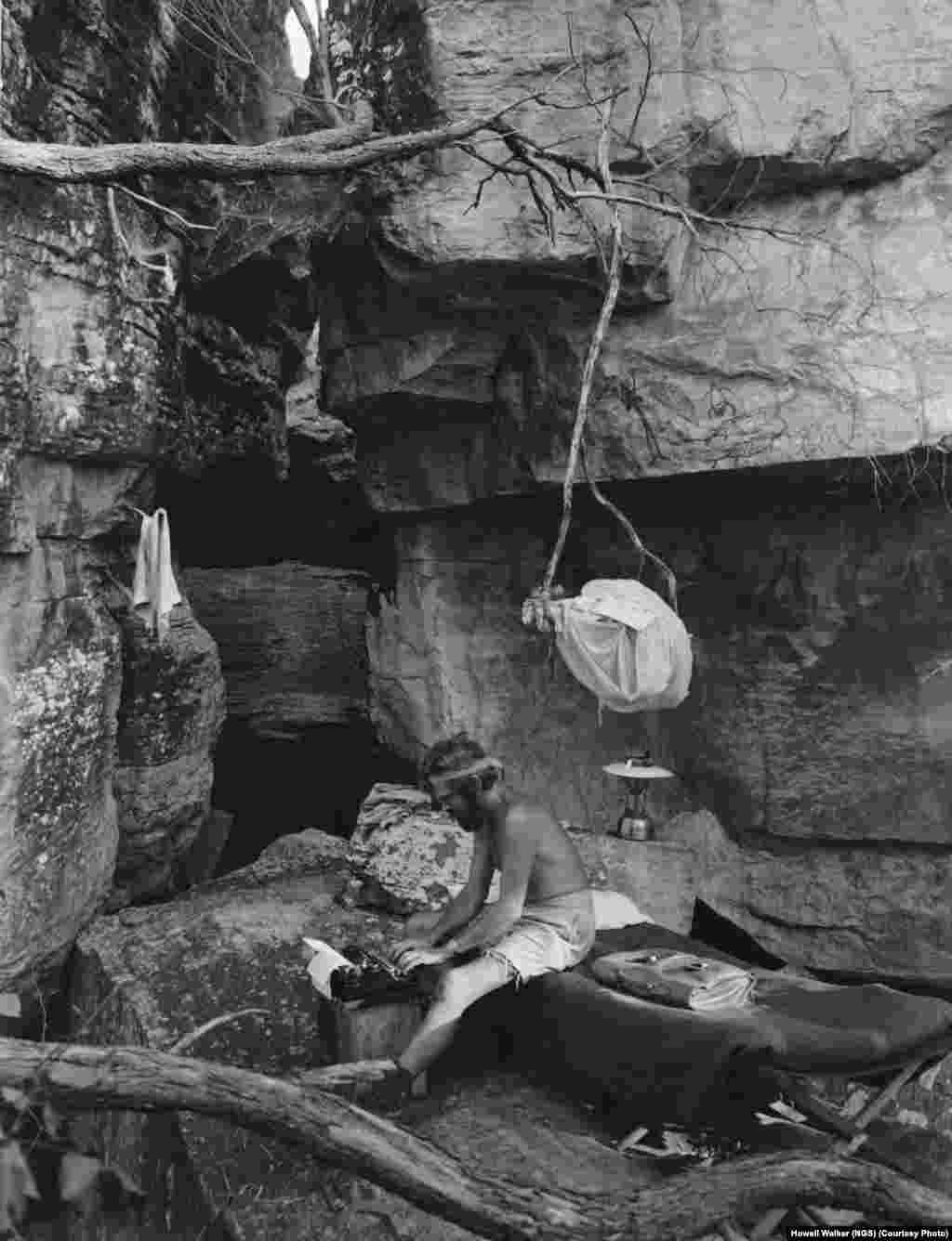 "National Geographic" magazine’s “Australia man,” photojournalist Howell Walker, types away in his “office” at Inyalark Hill, where he spent a week with Charles Mountford, leader of the Arnhem land expedition, in 1948.