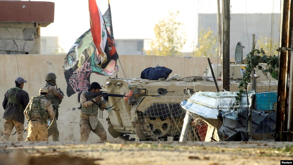 An Iraqi soldier aims his rifle during a battle with Islamic State fighters at the front line in a district of Mosul on November 4.