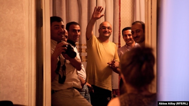 Azerbaijani journalist Eynulla Fatullayev waves to onlookers from his home in Baku after his release from prison in May 2011.