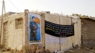 A poster on the home in Basra, Iraq of Diya Mitshar, an Iraqi who was fighting on behalf of the Syrian government before he was killed in Damascus.