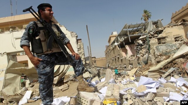 A policeman inspects damages following a June 4 bomb attack on the Shi'ite endowment headquarters in central Baghdad.