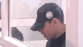 Defendant Vladislav Chelakh seen through the glass-enclosed dock in a screen grab from the start of the trial on November 19.