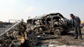 Mbetjet e makinës së djegur në lagjen Kadhimiya, pas sulmit me makinë-bombë